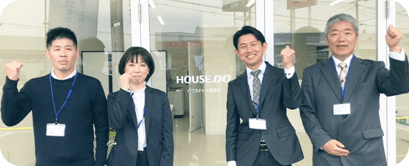 HOUSEDO店舗前でガッツポーズをするスタッフ4名
